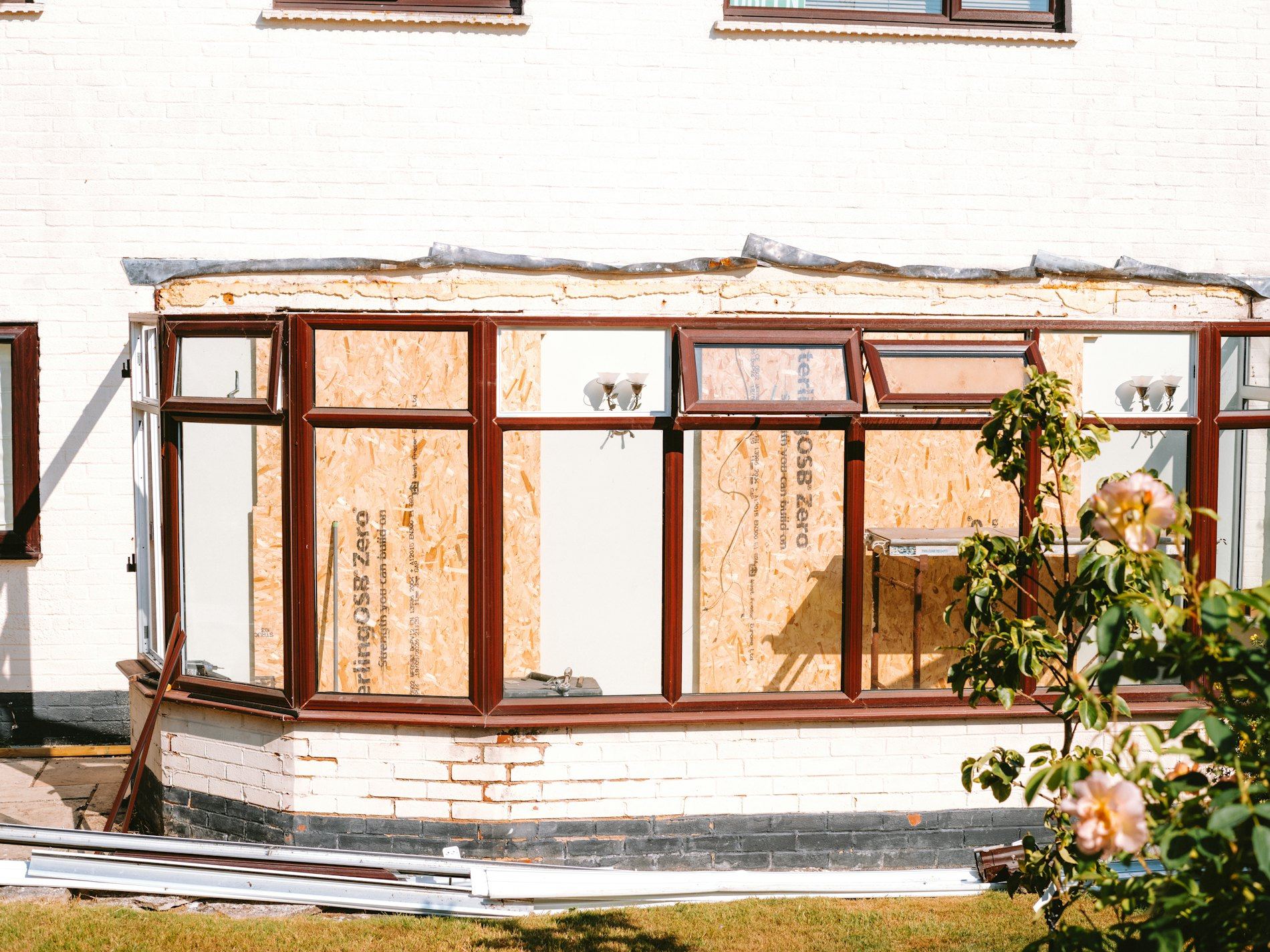 Conservatory under construction with boarded up windows.